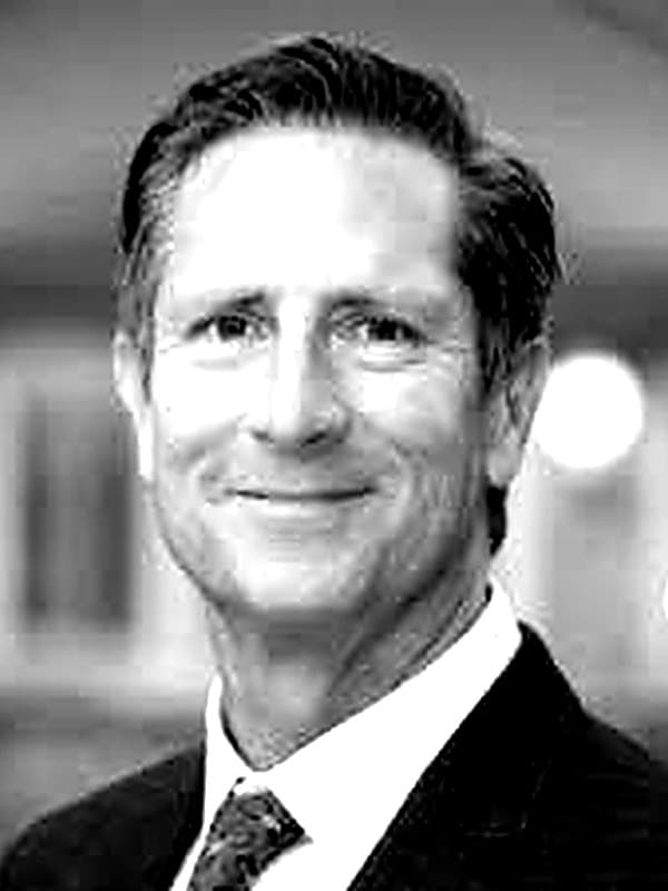 Portrait of Steve Pinedo, co-founder of Phi Longevity, in a dark suit and patterned tie